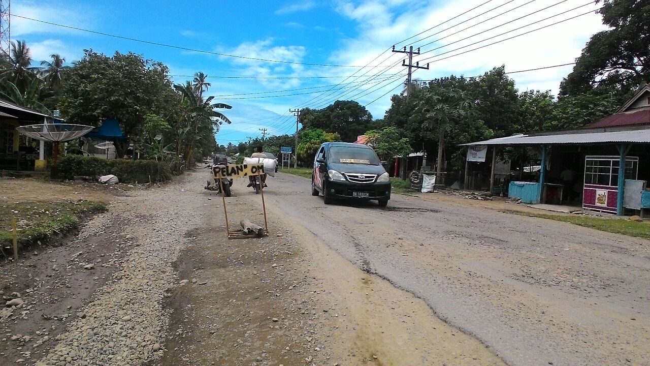 Plang bermerek "Pelan Om" berdiri tegak dijalan lintas Nasional (Jalinsum), tepatnya di kenagarian Taratak, Kecamatan Sutera, Kabupaten Pesisir Selatan (Pessel)