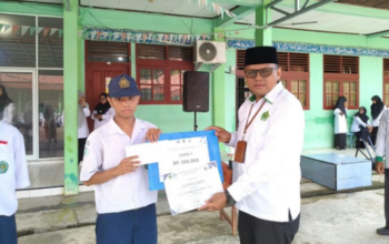 Kepala MTsN 5 Pesisir Selatan menyerahkan piagam KKPM kepada siswa berprestasi