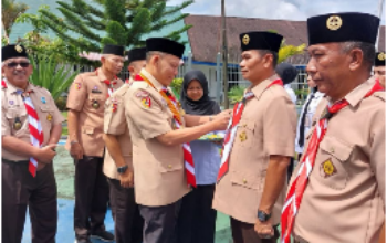 Ketua Kwarcab Pasaman Sabar AS memasangkan dasi Pramuka kepada Kepala Rutan Lubuk Sikaping Resman Hanafi