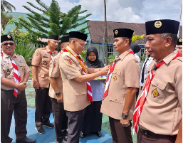 Ketua Kwarcab Pasaman Sabar AS memasangkan dasi Pramuka kepada Kepala Rutan Lubuk Sikaping Resman Hanafi