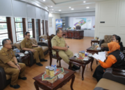 Bupati Asahan menyematkan perlengkapan kepada petugas Sensus Ekonomi 2026 di Aula Melati Kantor Bupati Asahan