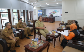 Bupati Asahan menyematkan perlengkapan kepada petugas Sensus Ekonomi 2026 di Aula Melati Kantor Bupati Asahan