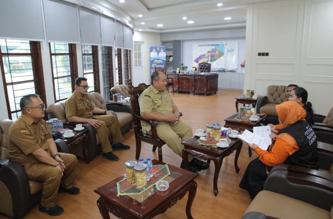 Bupati Asahan menyematkan perlengkapan kepada petugas Sensus Ekonomi 2026 di Aula Melati Kantor Bupati Asahan